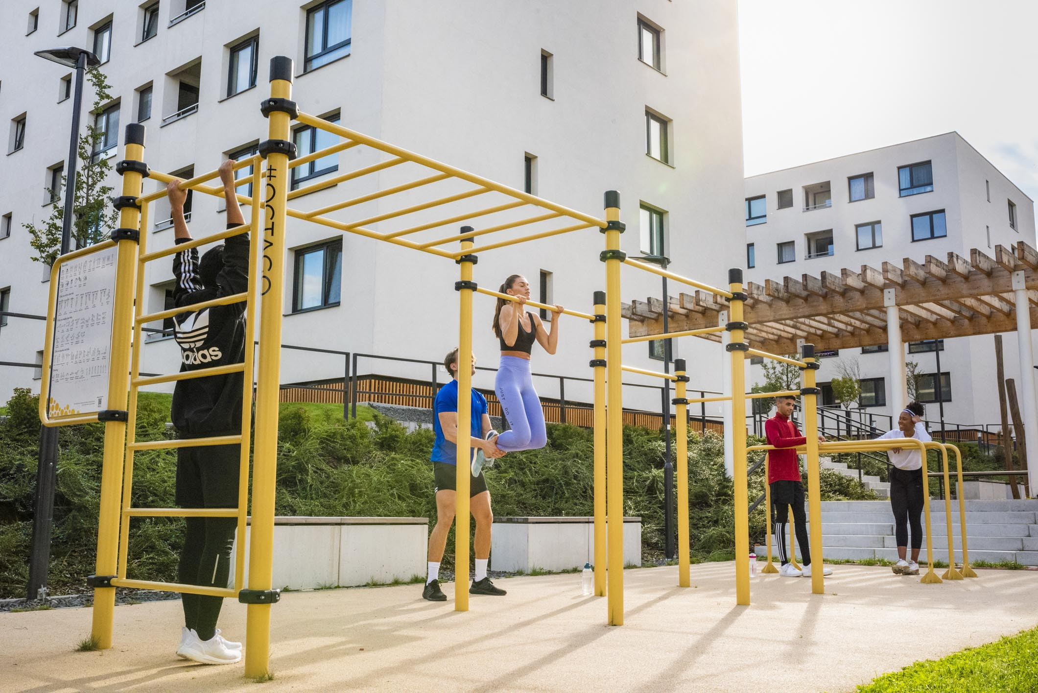 Workout playground with people exercising on yellow equipment
